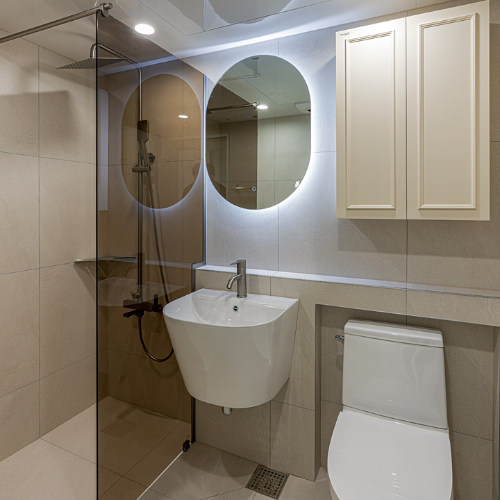 서울 동대문구 전농신성미소지움 아파트 30평, 간접 조명이 적용된 라운드형 거울로 감각적인 포인트를 더한 공용 욕실